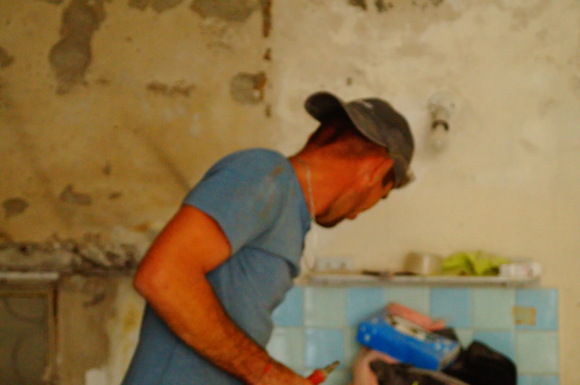 Maçon de profil dans une pièce en rénovation
