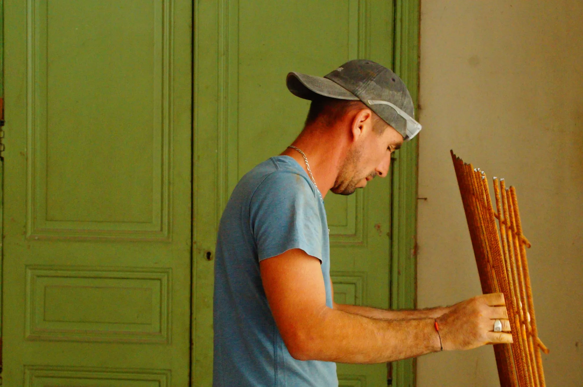 Maçon manipulant un panneau de treillis soudé