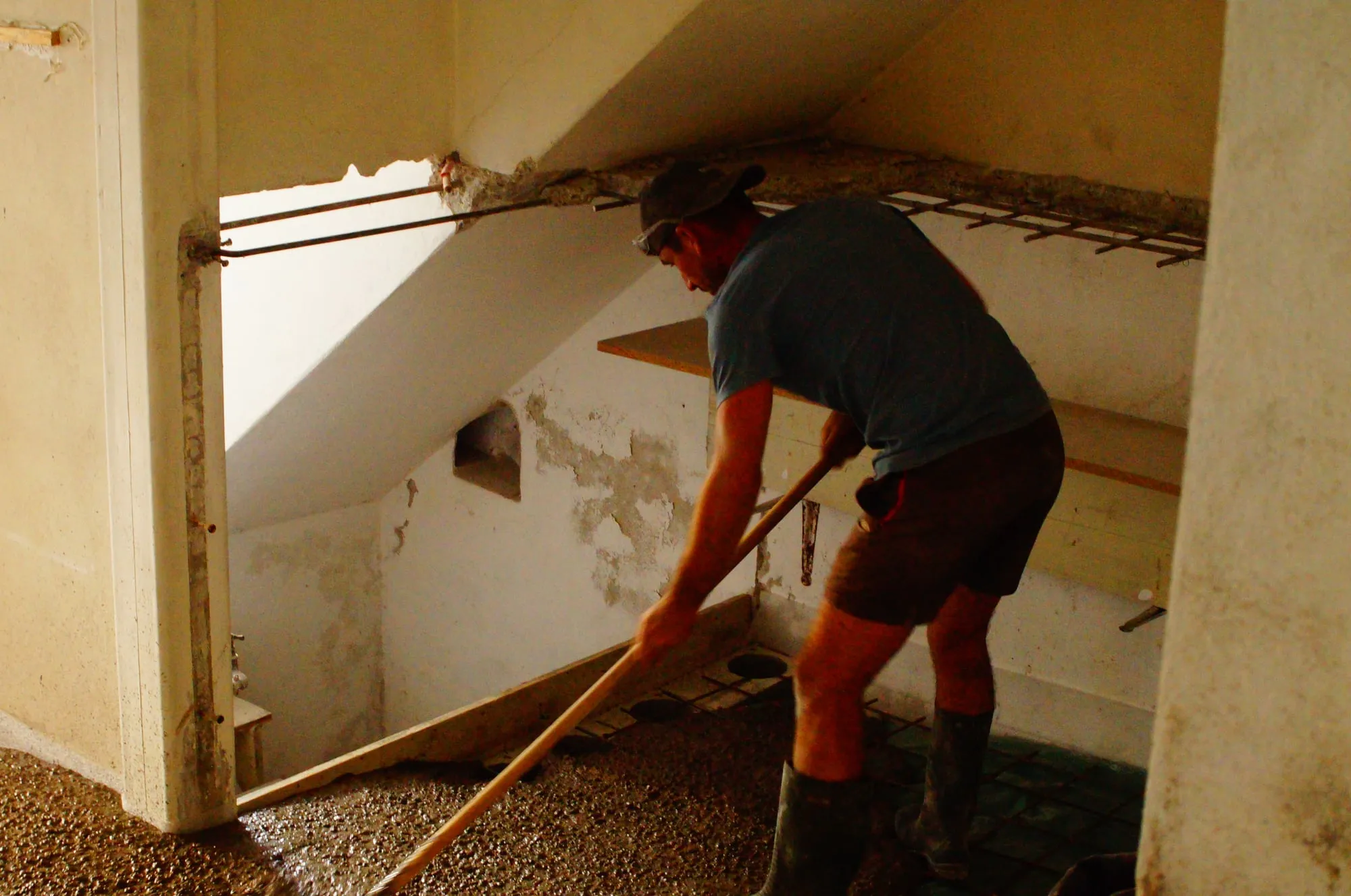 Maçon tirant le béton sous l'escalier