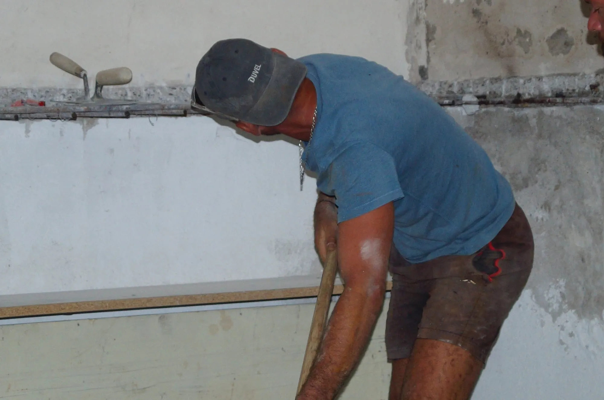 Maçon penché au travail le long du mur