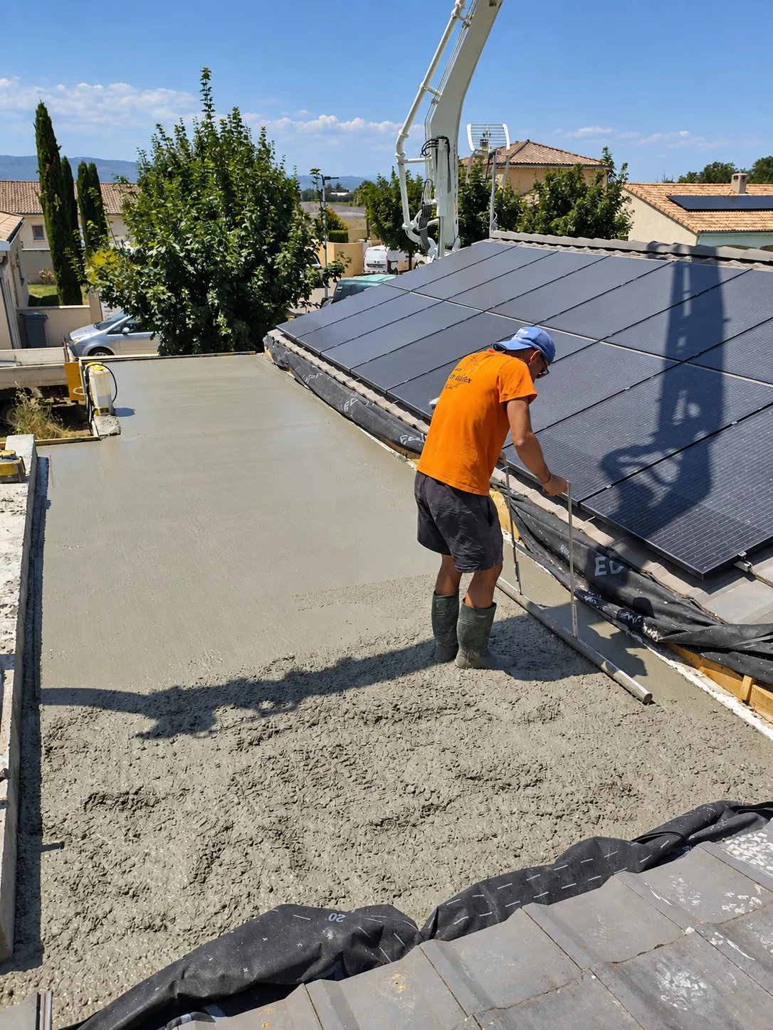 Maçon lissant la surface d'une dalle béton fraîchement coulée